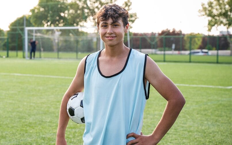 Boy with a soccer ball on his arms