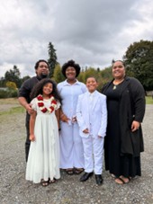 5 Black family members stand together outside for a photo